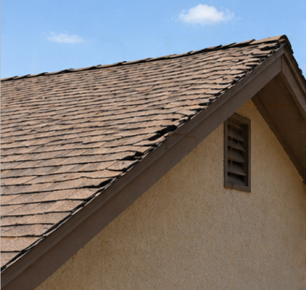 Side-angle view of a roof ridge that appears uneven and no longer straight on a residential home.
